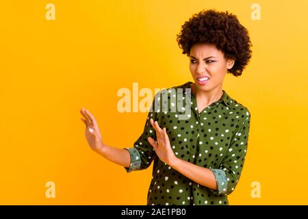 NO. Photo of beautiful dark skin lady holding hands in protecting gesture deny communication with chatterbox person wear green dotted shirt isolated Stock Photo