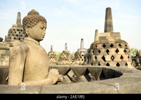 (Selective focus) Stunning view of a Buddha Statue in the foreground and some bell shaped stupas in the background. Stock Photo