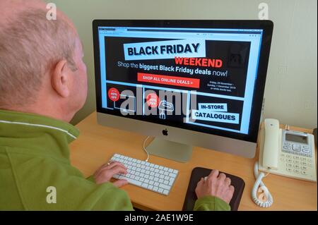 Man person looking at website on Black Friday internet shopping computer screen England UK United Kingdom GB Great Britain Stock Photo