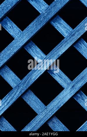 Wooden fence lattice toned blue. Wood grating close up. Abstract wood texture. Vertical frame. Stock Photo