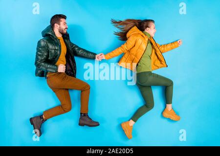 Side profile top above high angle view full length body size photo of cheerful positive handsome beautiful couple holding hands running to shop in Stock Photo
