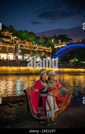 Feng Huang, China -  August 2019 : Chinese family female generations dressed in traditional folk costumes posing for a photo on the riverbank of Tuo r Stock Photo