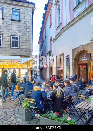 Tourists in a small piazza drinking beer in alfresco bar pub in Old Town Prague Czech Republic. Stock Photo