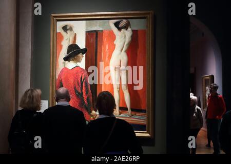Visitors study a self-portrait with a model by Dame Laura Knight at the National Portrait Gallery, London, UK
