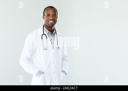 Joyful afro american doctor holding his hands in the pockets Stock Photo