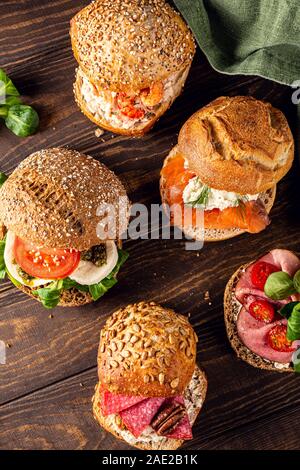 Assorted sandwiches on wooden table Stock Photo