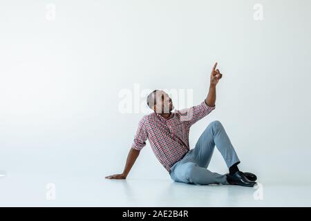 Cheerful afro american man sitting ont he floor Stock Photo