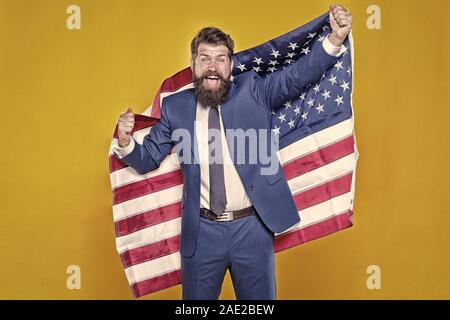 American by birth. Rebel by choice. Confident businessman handsome bearded man in formal suit hold flag USA. Business people. Businessman concept. Successful businessman well groomed appearance. Stock Photo