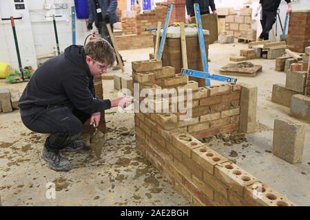 A bricklaying student works on a simple wall section at Suffolk New College, Ipswich, UK Stock Photo
