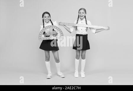 Explore world with math. Discover mathematics patterns. Mathematical theory combining algebraic and geometric methods. School students study geometry. Pupil school girls big rulers. School knowledge. Stock Photo