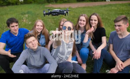 Happy cheerfulfriends launch a drone from their hands. Stock Photo