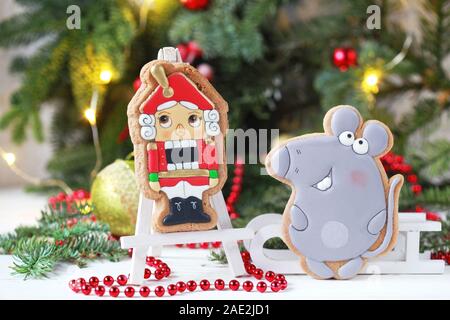 Homemade christmas gingerbreads painted as a mouse and Nutcracker on the white background with fir branches. Selective focus and place for text. Stock Photo