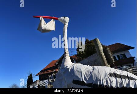 Buching, Germany. 06th Dec, 2019. A homemade stork figure with a bag in its beak symbolizes the birth of a baby in front of a farm. Credit: Karl-Josef Hildenbrand/dpa/Alamy Live News Stock Photo