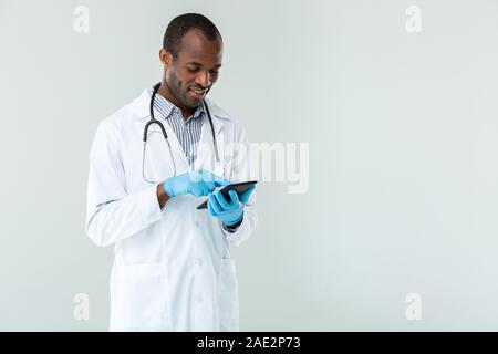 Positive afro american doctor standing against white background Stock Photo
