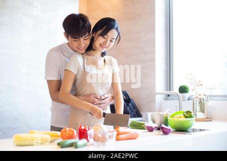 Happy young couple cooking in kitchen Stock Photo