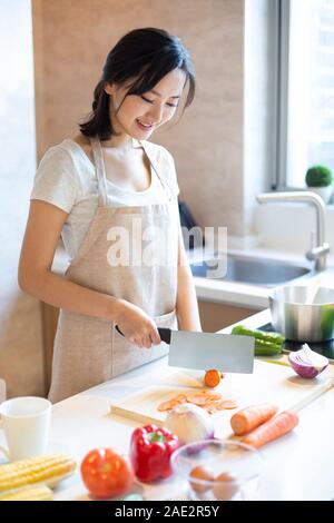 Young woman cooking in kitchen Stock Photo