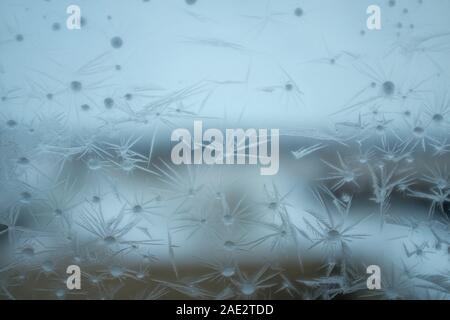 Delicate patterns of ice crystals on a frosted window conceptual of winter and the seasons viewed looking out from inside Stock Photo