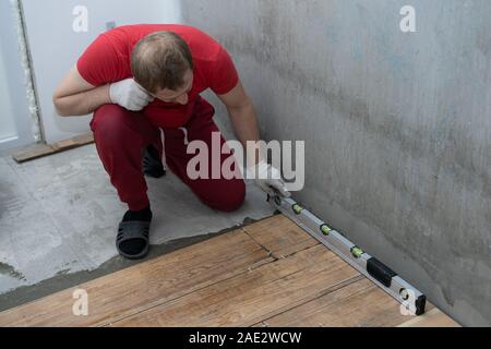 repair and decoration. the tiler puts the porcelain tiles on the floor in the apartment. Stock Photo