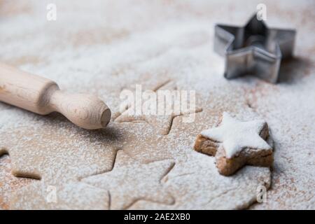 Ginger dough and other Christmas baking ingredients on the table. Star shape cookies preparation. Stock Photo