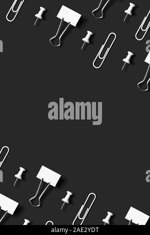 White office supplies, paper clips, pushpin and binder clips organized neatly over black background, top view Stock Photo