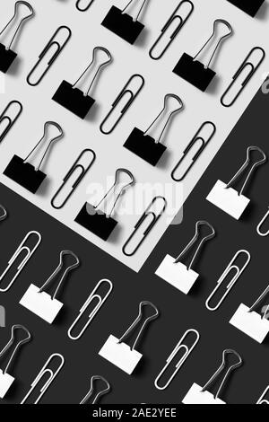 Office supplies, paper clips and binder clips organized neatly over black and white background, top view Stock Photo