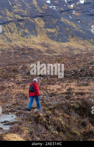 Woman walking at Black Cuillin and Fairy Pools, river Brittle, Isle of Skye, Scotland, UK in March Stock Photo