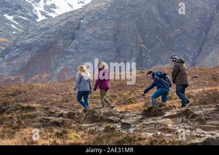 Friends walking at Black Cuillin and Fairy Pools, river Brittle, Isle of Skye, Scotland, UK in March Stock Photo