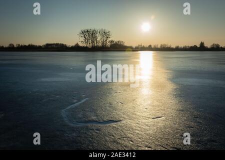 Frozen lake and the sun shining on the ice surface, eastern Poland Stock Photo