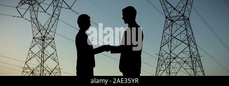 Composite image of silhouettes shaking hands Stock Photo