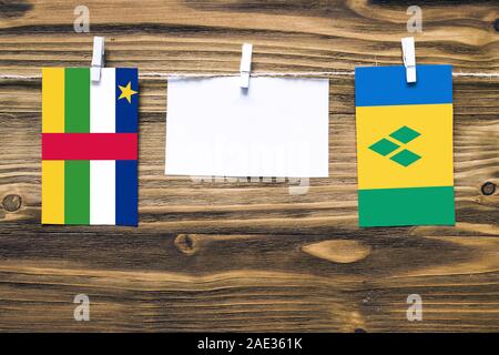 Hanging flags of Central African Republic and Saint Vincent And The Grenadines attached to rope with clothes pins with copy space on white note paper Stock Photo