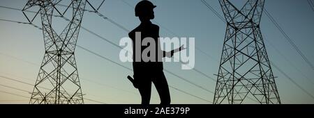 Composite image of female architect holding clipboard and blueprint against grey background Stock Photo