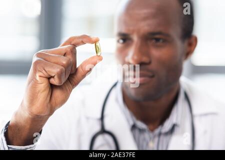 Focused photo on male hand that keeping pill Stock Photo