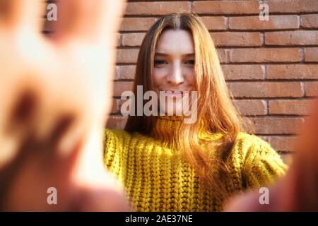 Young Redhead Woman Covering Camera Lens With Hands Stock Photo