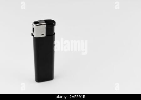 Close-up of a black plastic lighter and chromed metal housing, standing, on white background Stock Photo