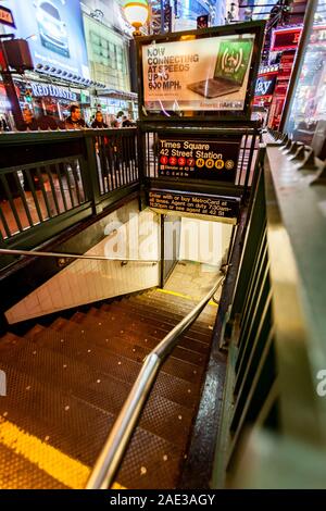 Times Square subway station entrance with the bright neon lights of the NYC landmark district visible in the background. Stock Photo