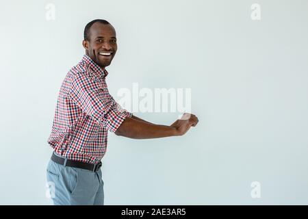 Joyful afro american man pushing the cart against white background Stock Photo