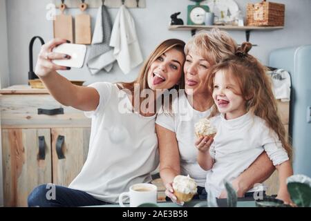 Playing with kid. Mother, grandmother and daughter having good time in the kitchen Stock Photo