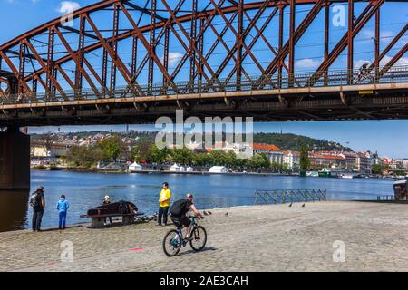 Prague iron bridge, Zeleznicni most over Vltava River Prague Czech Republic Man ride bicycle Vltava in Prague railway bridge river Vltava Prague Stock Photo