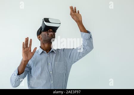 Waist up of positive afro american businessman wearing VR goggles Stock Photo