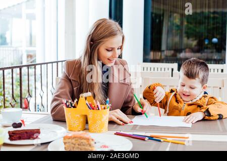 mother and son in the restaurant painted pencils before eating Stock Photo