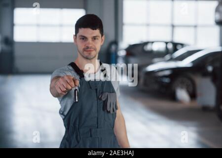 Your welcome. Hand of mechanic with keys. Your car is on the way again. Job well done Stock Photo