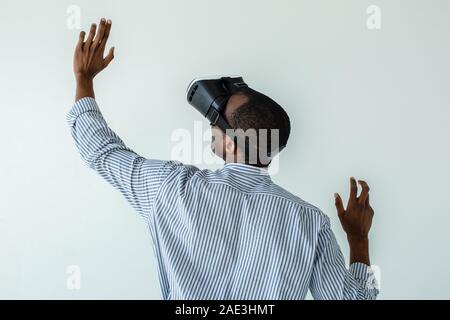 Rear view of a curious afro american man testing VR glasses Stock Photo