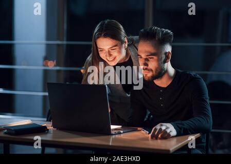 Coworking gives good results. Team of young business people works on their project at night time in the office Stock Photo