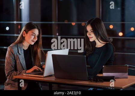 Money will be ours. Team of young business people works on their project at night time in the office Stock Photo