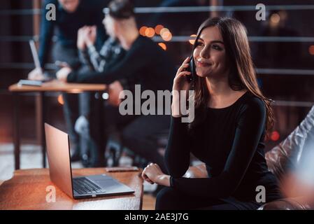 Pick up the phone please. Team of young business people works on their project at night time in the office Stock Photo