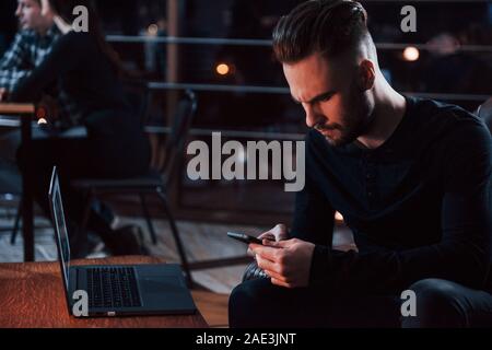 Money is too important for this guy. Stylish young businessman works alone in the office at nightime Stock Photo