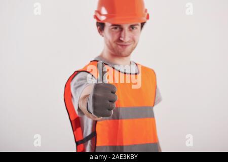 Focused photo. Man in orange colored uniform stands against white background in the studio Stock Photo
