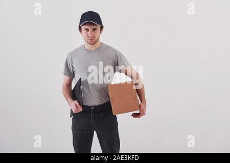 On my way. Guy with box in hands stands against white background in the studio Stock Photo