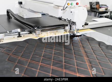 Programmable sewing machine embroider a pattern on a fabric. Innovative technologies in light industry and sewing business Stock Photo