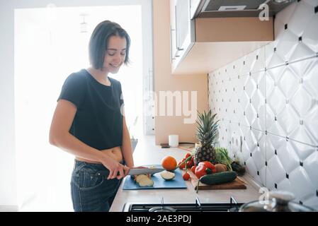 Alone in the room. Girl in the modern kitchen at home at her weekend time in the morning Stock Photo